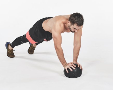 Man performing medicine ball press-up