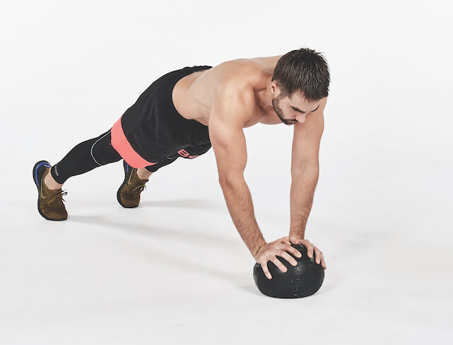 Man performing medicine ball press-up