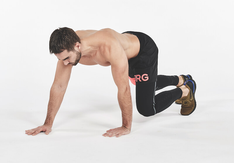 topless man demonstrates how to perform forward and back bear crawls exercise