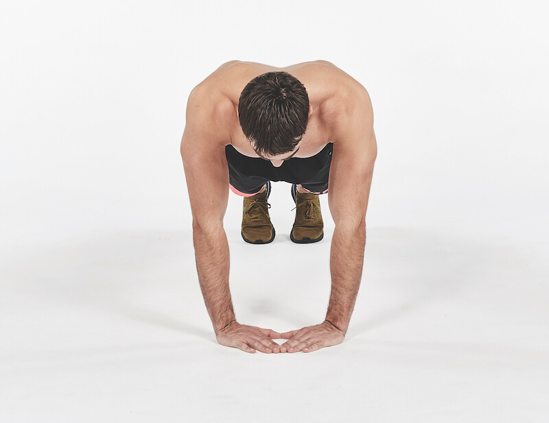 topless man demonstrates diamond push-up exercise, one of the best workout finishers