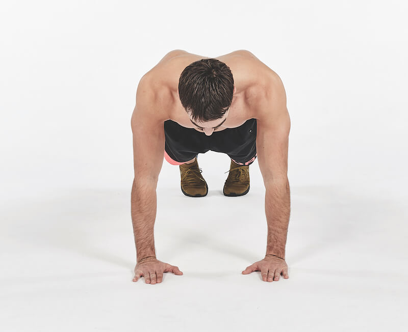 topless man demonstrates how to do push up exercise