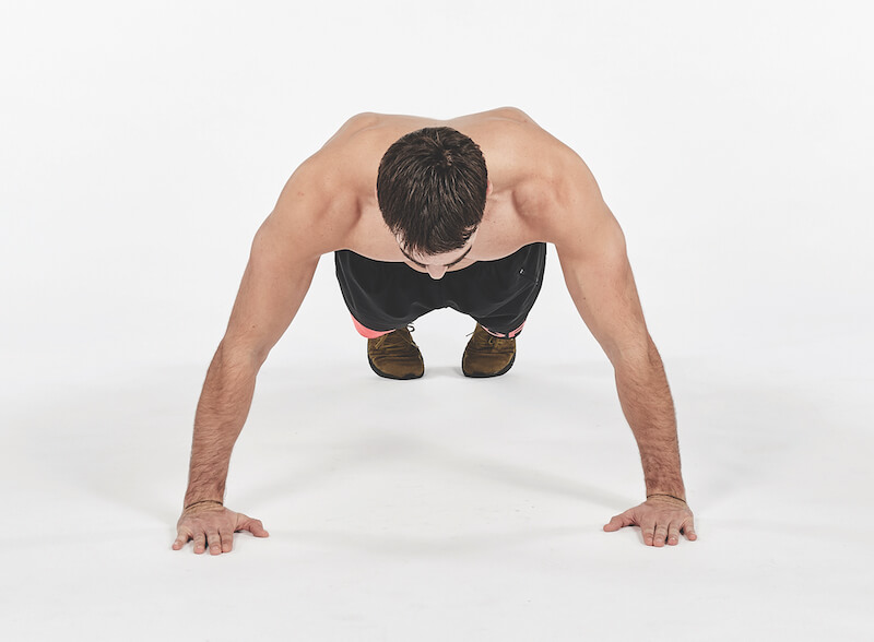 man demonstrates how to do wide push up exercise