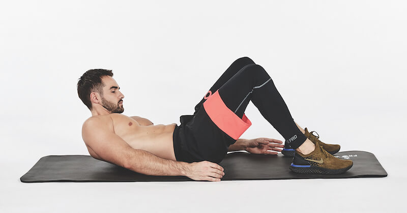 topless man demonstrates alternating ankle touches on floor, one of the best workout finishers