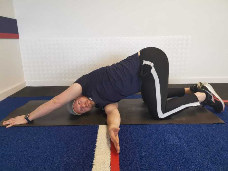 Man performing a thread-the-needle stretch