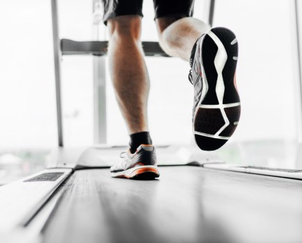 man wearing gym trainers while running on treadmill