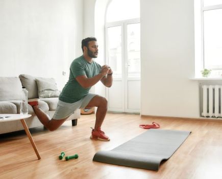 A man performing mobility stretches at home