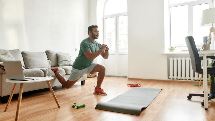 A man performing mobility stretches at home