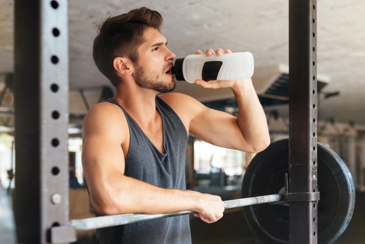 A man in a gym drinking water
