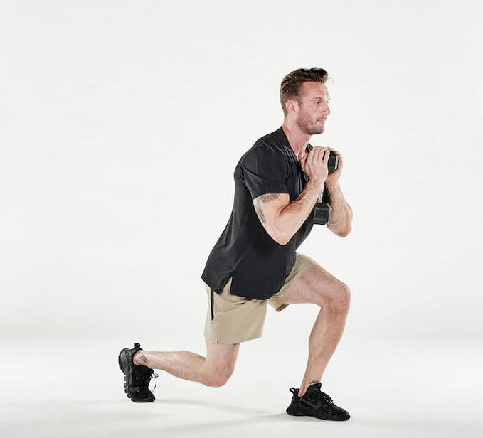 man performs forward lunge with dumbbell