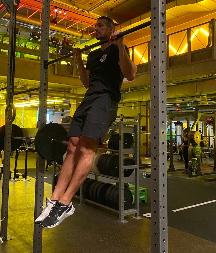 man performing pull-up in gym