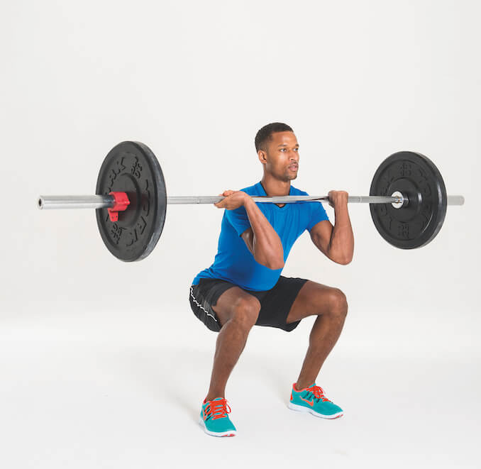 man performing barbell hang squat clean