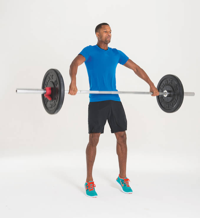 man performing the second stage of a barbell shrug