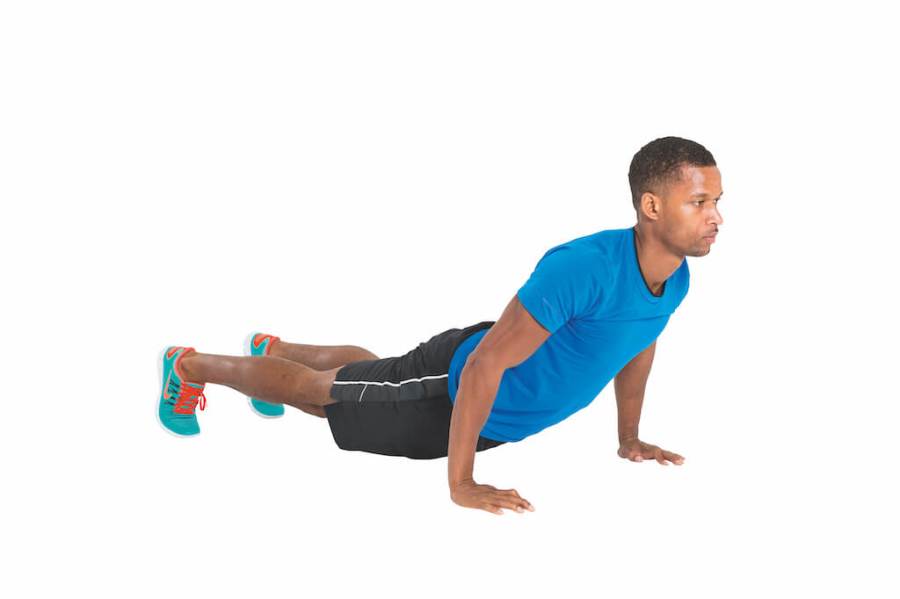 man in blue t-shirt and shorts performing upward dog yoga pose