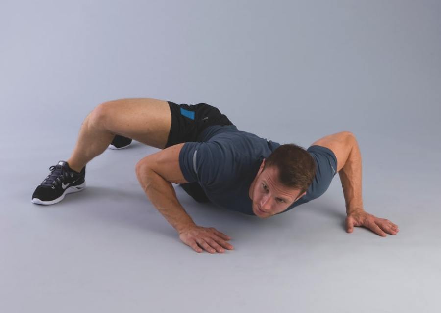 man performing alligator press-up