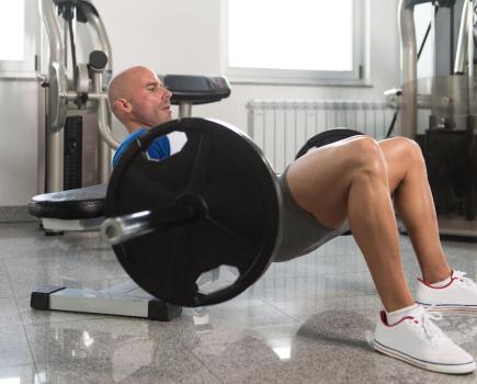 man performing barbell hip thrust to show barbell hip thrust benefits