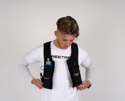 Man in white t-shirt putting on the Freetrain Hydro 1 Vest