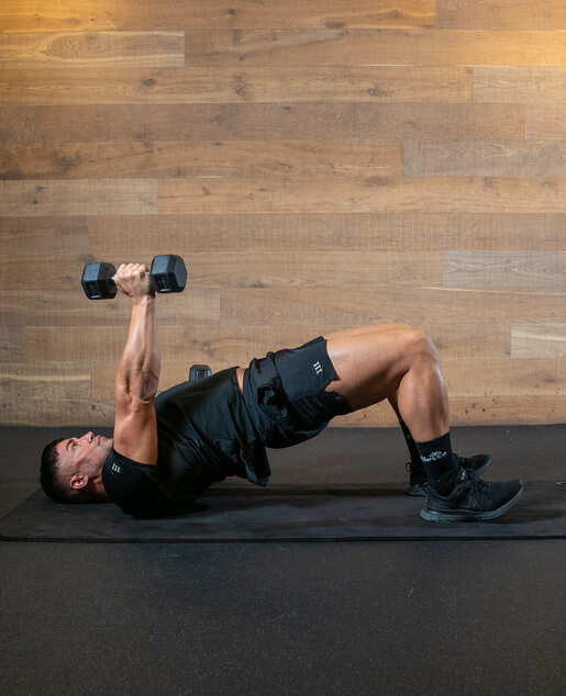 man demonstrating alternating floor presses in bridge