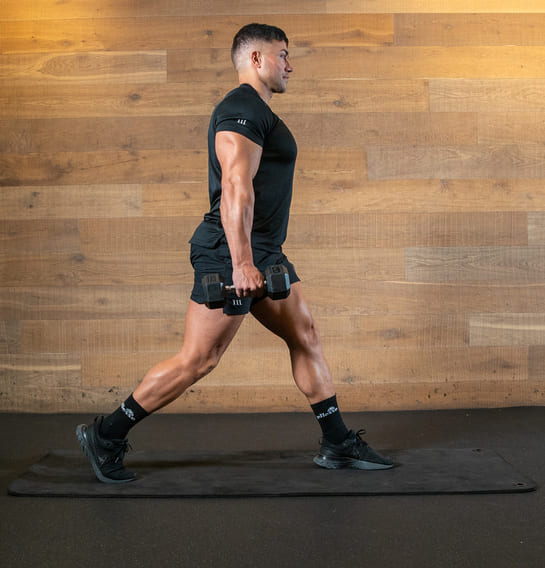 man demonstrates suitcase hold split squat in best full body dumbbell workout