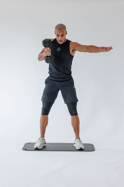 dumbbell single arm snatch demonstration step 3: As the dumbbell reaches shoulder height, flip your elbow underneath the weight and press it overhead, locking out your elbow.  