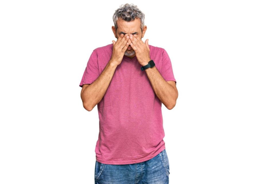 man holds his face in his hands