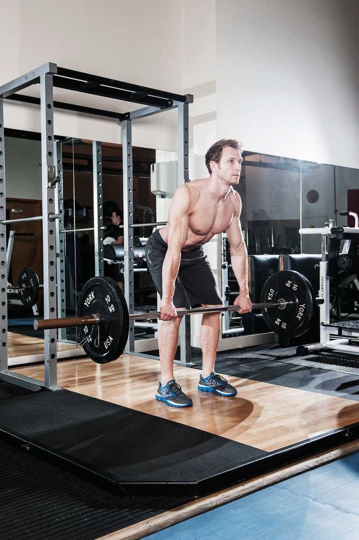 man demonstrates how to build back muscles with bent over barbell row