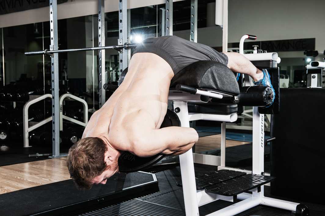 man demonstrates weighted back raise