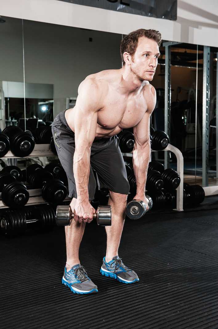 man demonstrates how to do a dumbbell bent over row in the gym