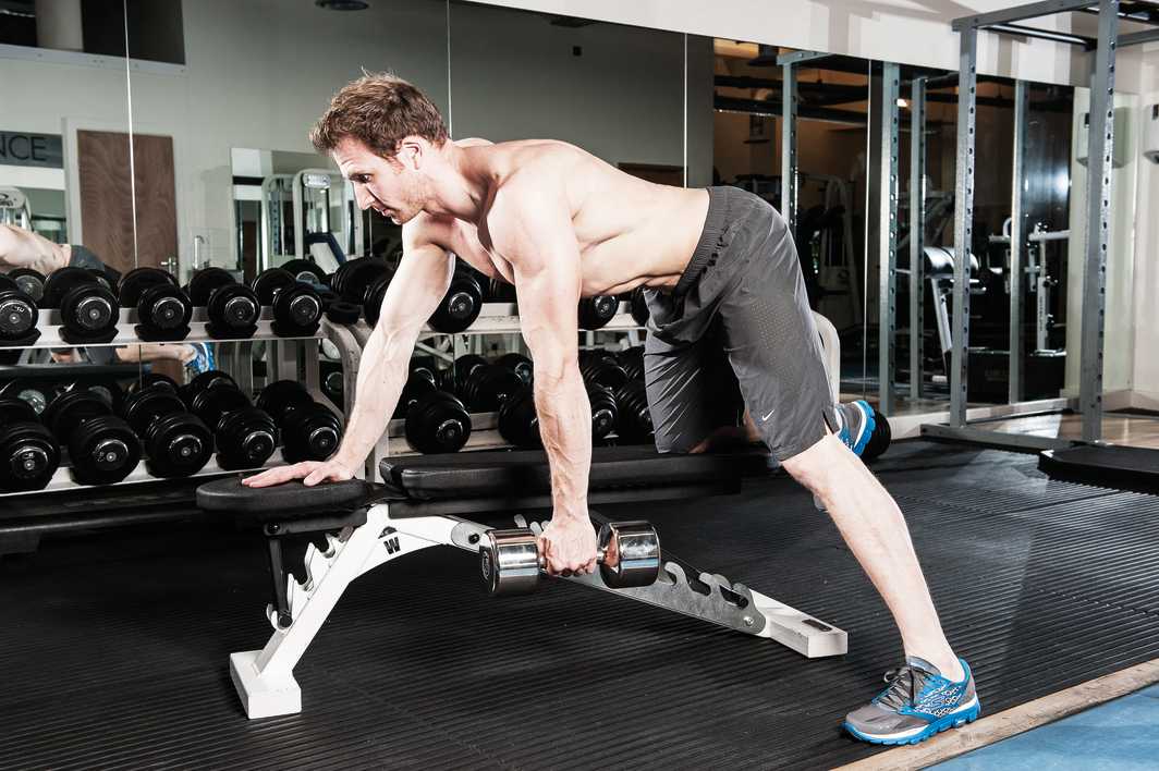 man demonstrates single arm dumbbell row to build back muscles