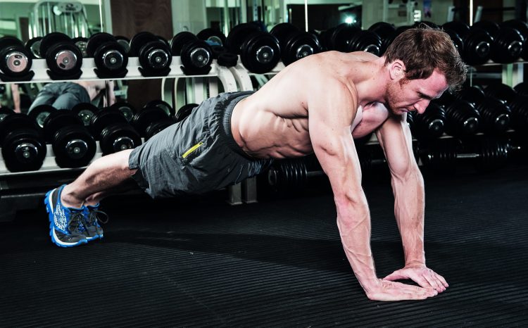 Man perfoming diamond press-up in gym - how to grow bigger arm muscles