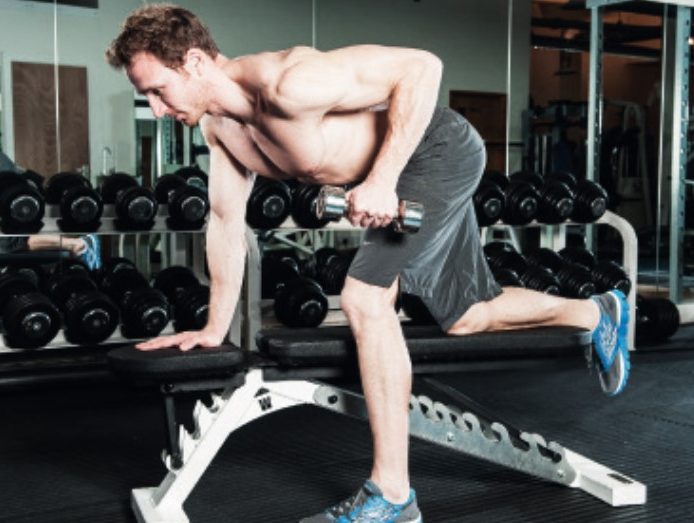 Man performing the dumbbell triceps kickback - how to build bigger arm muscles