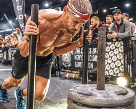 Michael Sandbach, the UK's fastest HYROX athlete, pushing a sled during a HYROX event