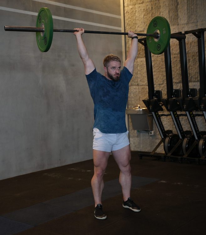 Man performing end of barbell press - best shoulder press variations