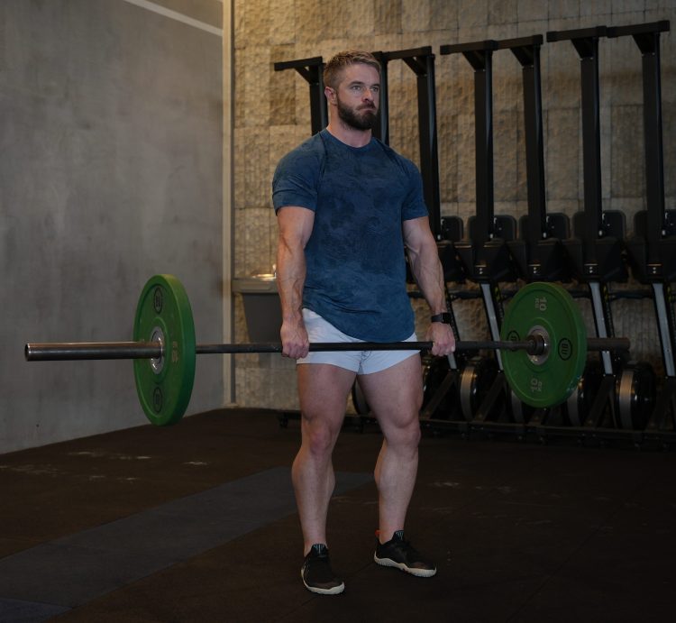 Man performing end of dumbbell deadlift - best deadlift variations