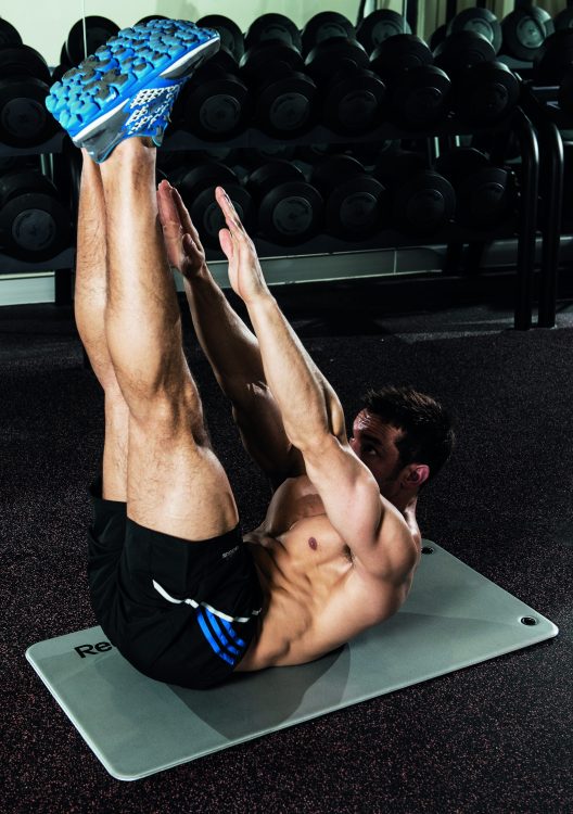 Man on a gym floor performing the end of the jackknife exercise