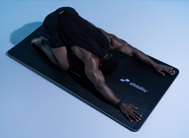 Athlete performing the child's pose on a yoga mat