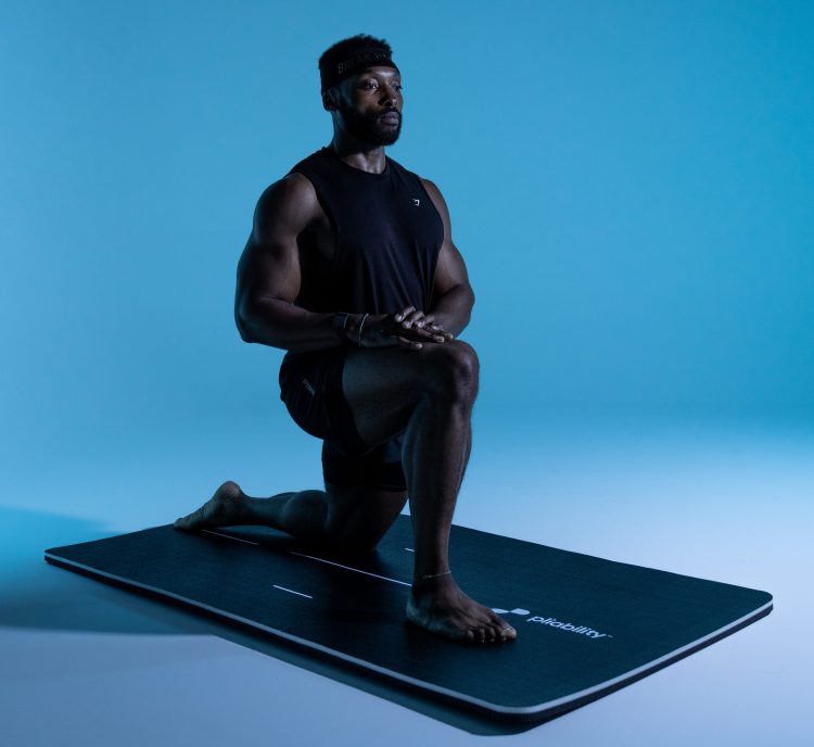 Athlete performing a dragon's pose on a yoga mat