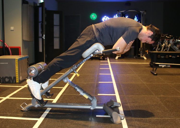 A man performing a low back hyperextension - best low back exercises