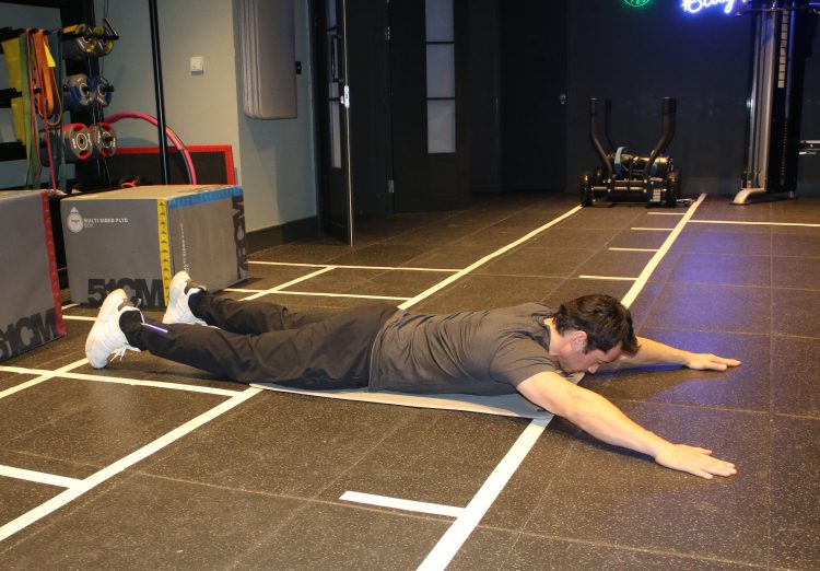 Man performing a superman exercise - best lower back exercises