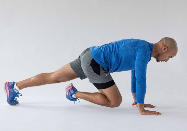 Man performing a pigeon stretch - best hip stretches