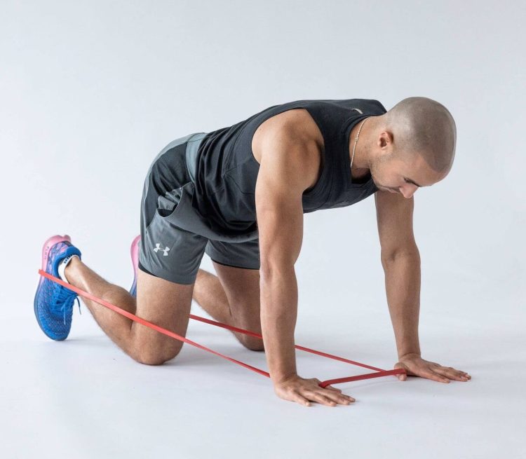 Man performing a banded kickback - resistance band leg exercises