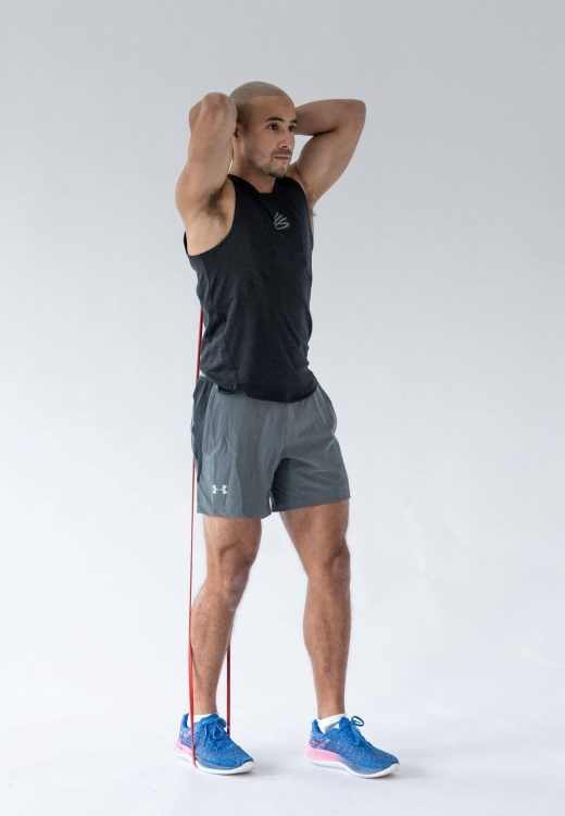 Man performing a banded overhead triceps extension - resistance band arm exercises