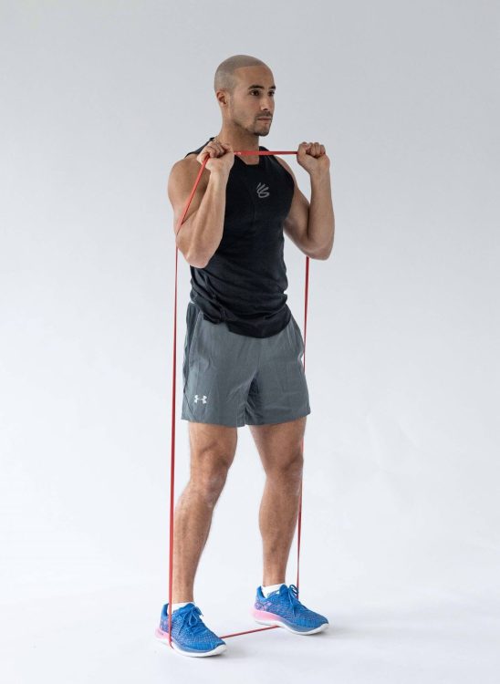 Man performing a banded shoulder press - resistance band arm exercises