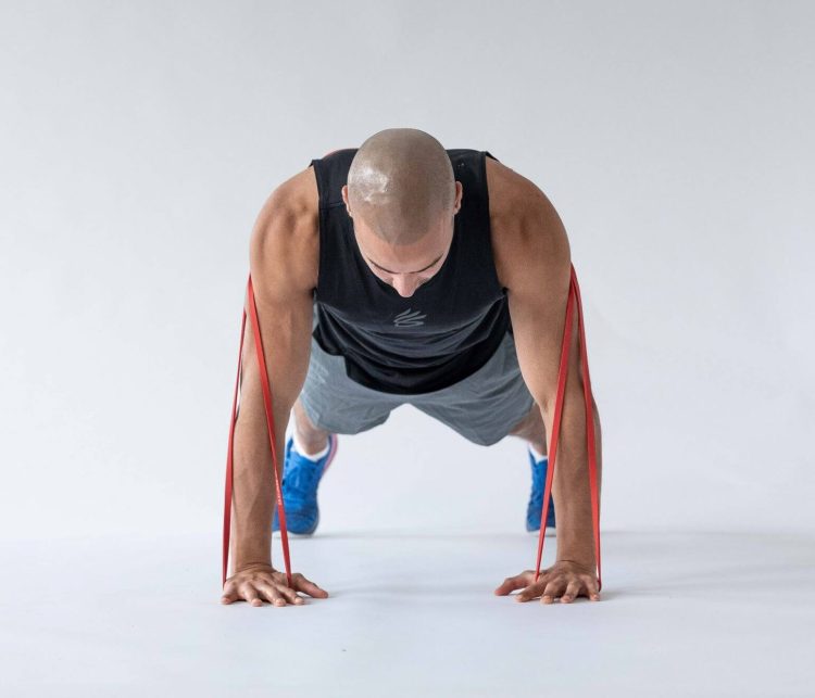 Man starting a banded triceps press-up - resistance band arm exercises