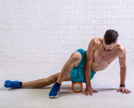 Man using a foam roller on his hips