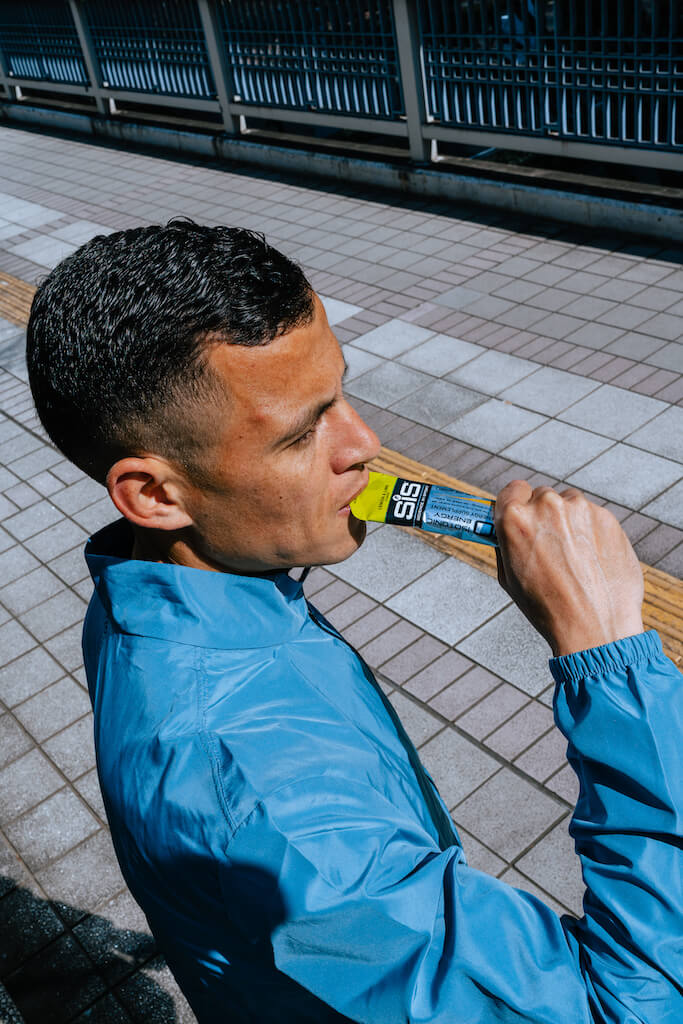 close up of runner using Science in Sport energy gel to demonstrate how to fuel for a half marathon