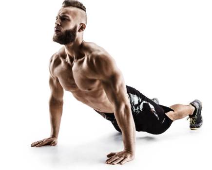 man performing stretch against white background as warm-up to a fat loss hiit workout