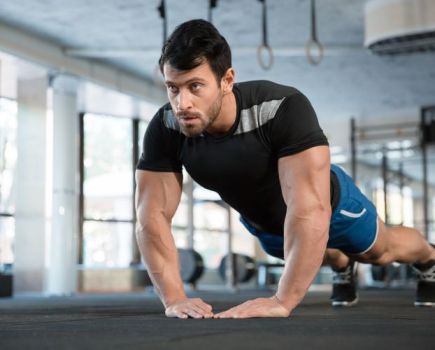 Man in a gym performing pushups