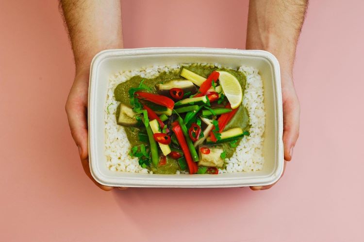 Overhead view of a vegetable Thai green curry takeaway box