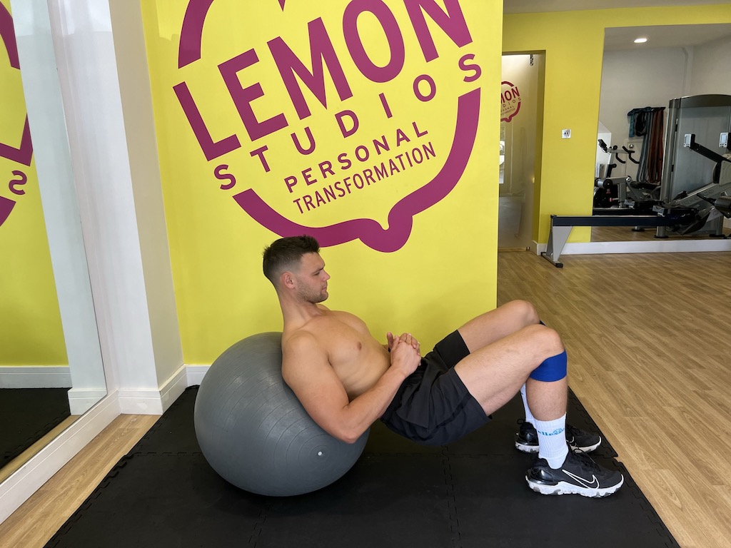 Man performing banded exercise ball hip thrust