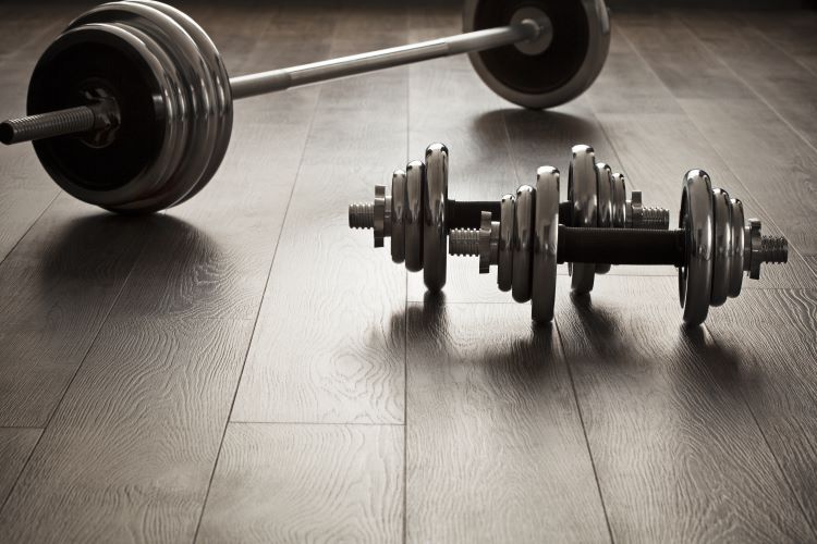 Dumbbells and a barbell on a wooden floor